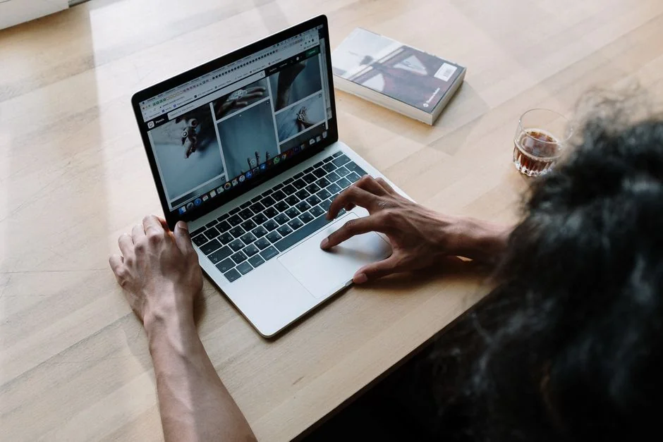 Hands typing on a laptop with cryptocurrency charts and smartphone display in view, focusing on digital finance.